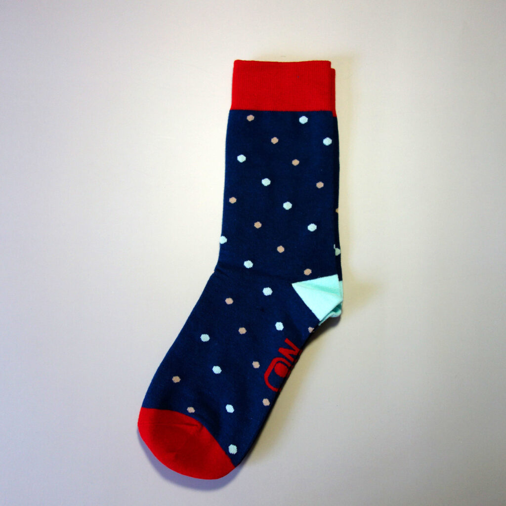 A custom made sock with logo on foot, and dotted stars over the sock tube. Base color: dark blue. Cuff & toe color: Red