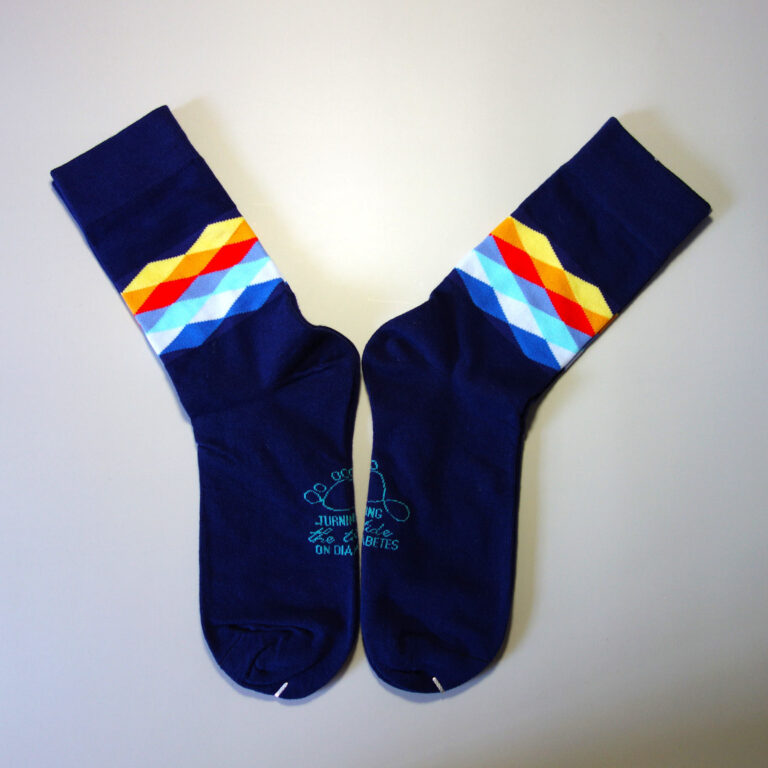 Custom logo socks with colorful diamonds. The logo is knitted on to the sole of sock. Base color: Dark blue. Secondary color: yellow, orange, red, blue, white